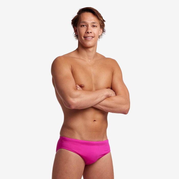 Funky Trunks men's Still Pink Classic Brief in bright pink with a snug fit and soft fabric, showcased on a model.