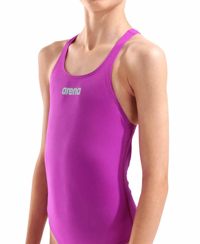 Arena girls' solid Team Swim Pro swimsuit in vibrant fuchsia and water blue, featuring sleek, fitted design for swimming.