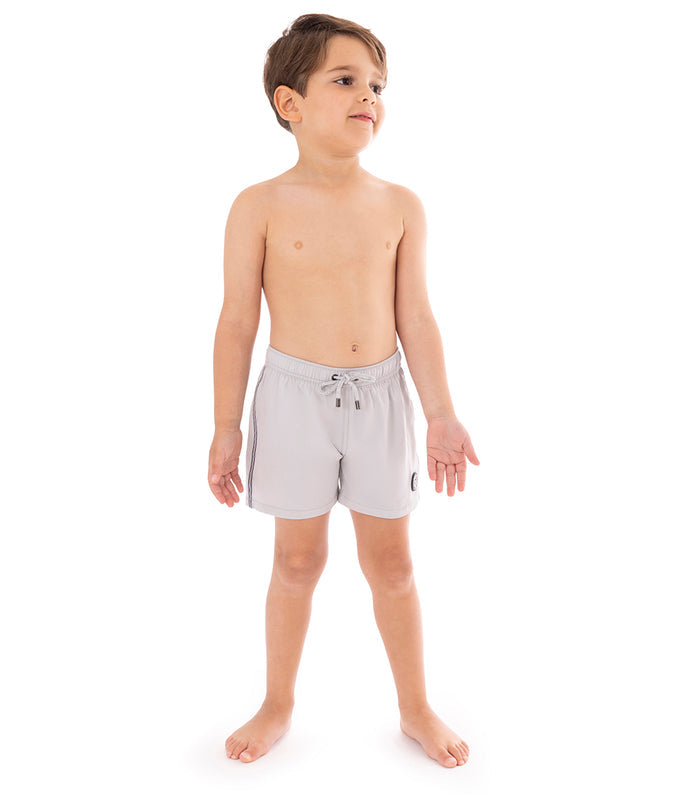 Gray Young boy wearing light gray shorts on a white background