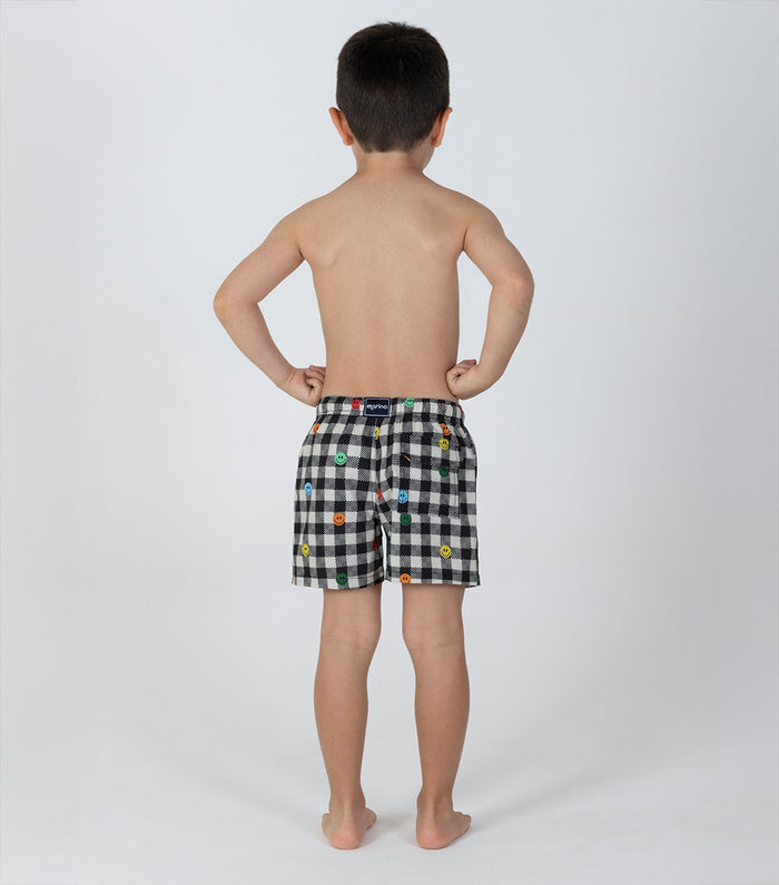 gingham emoji Child wearing black checkered shorts with colorful patterns on a white background