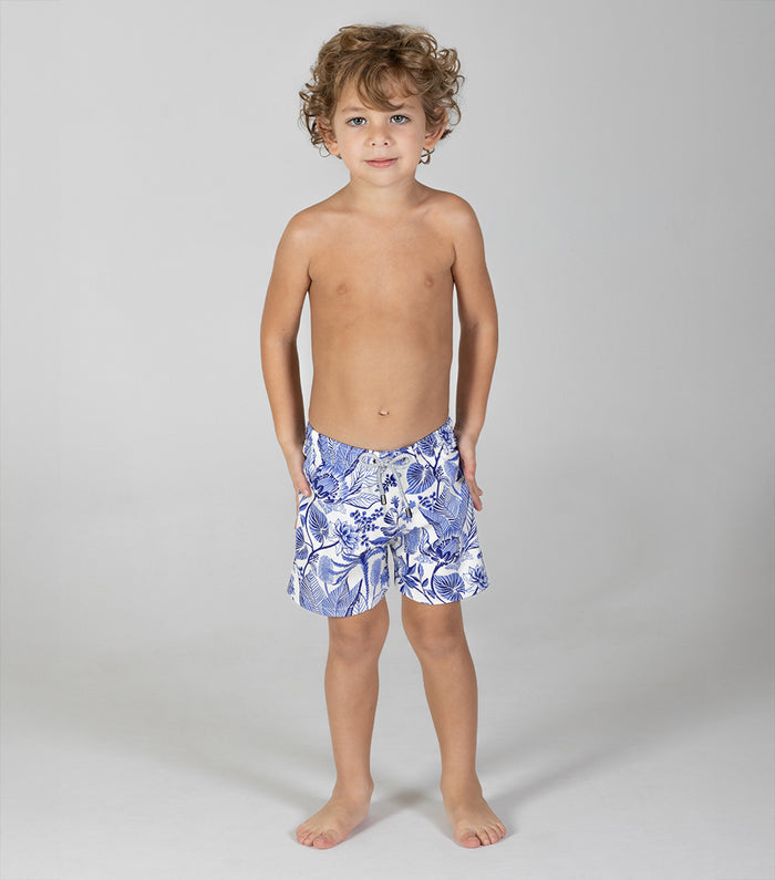 tropical Child wearing blue floral swim shorts on a gray background