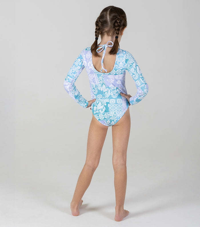 paisley Girl wearing a blue and white floral swimsuit with long sleeves on a gray background