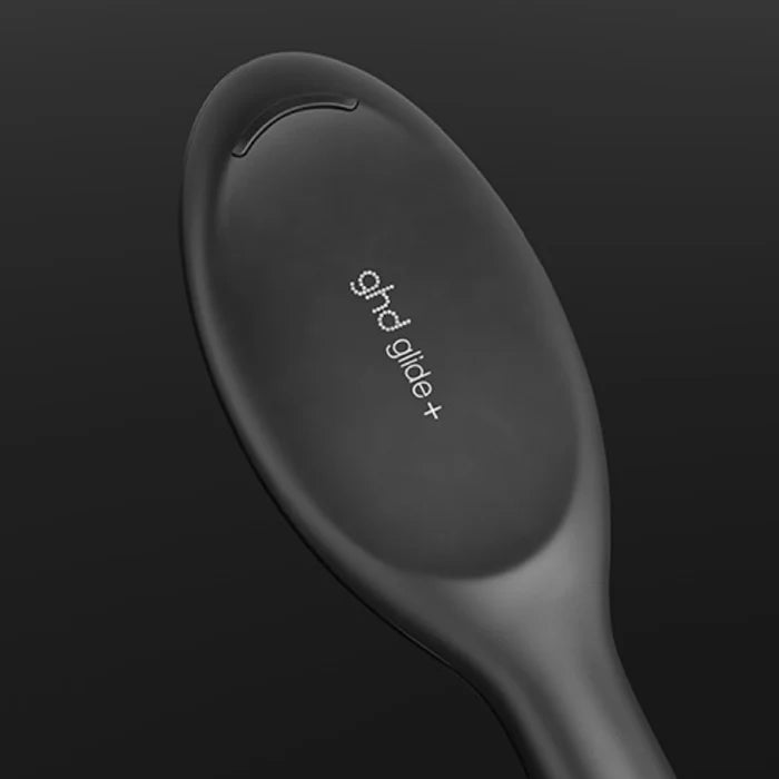 Black hair straightener with 'ghd' branding on a dark background