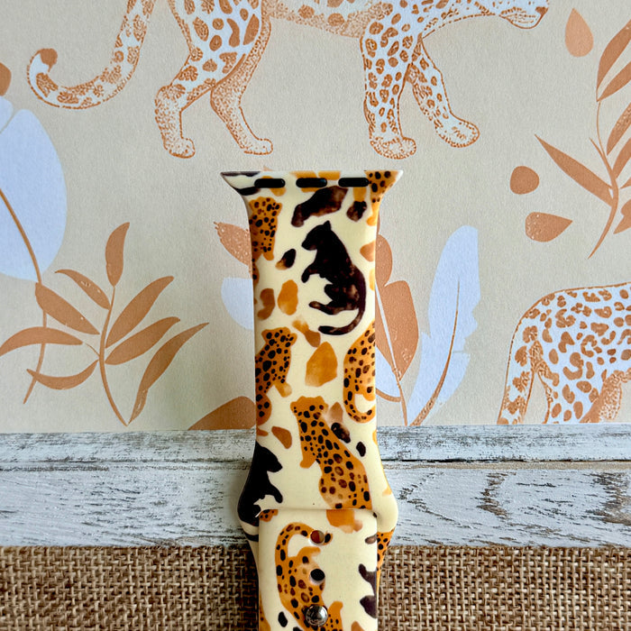 Golden Wildcat Apple Watch band with spotted leopards in golden and brown tones on cream background with safari wallpaper