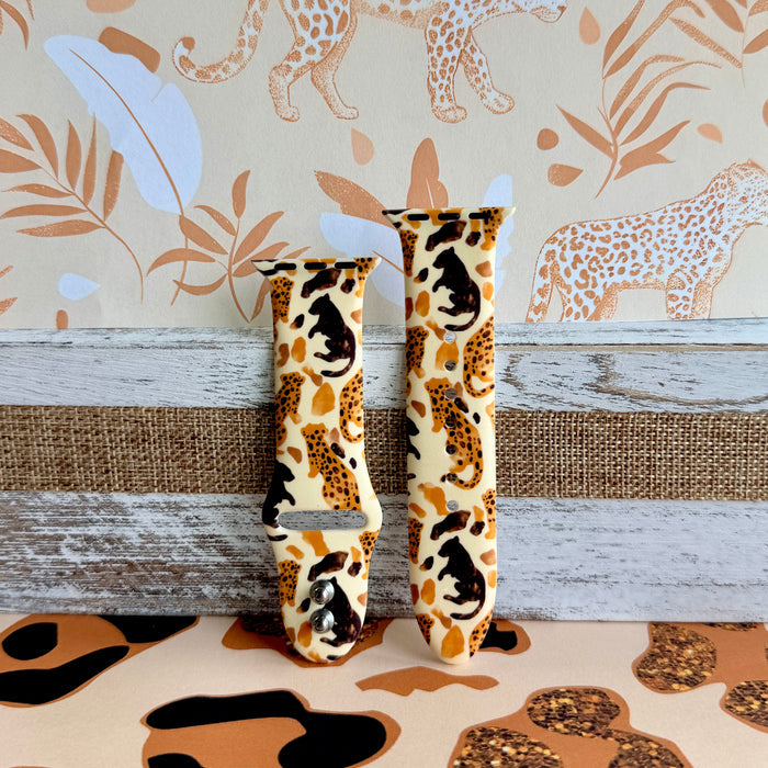 Golden Wildcat Apple Watch band with spotted leopards in golden and brown tones on cream background with safari wallpaper