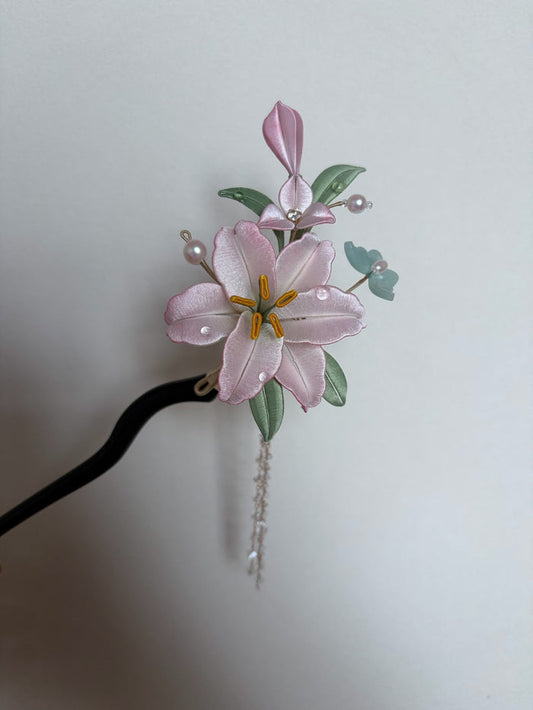A handmade Chanhua lily hairpin with pink petals and green leaves