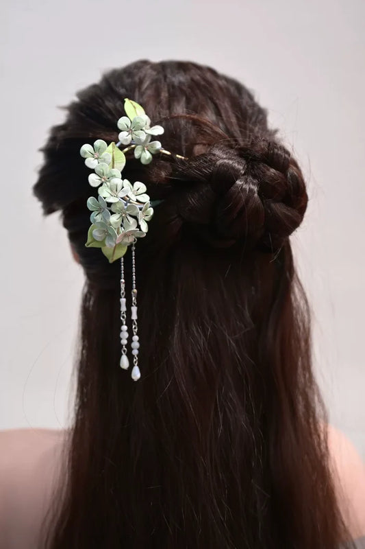 A woman wearing a handmade Chanhua silk hydrangea hairpin with beaded tassels