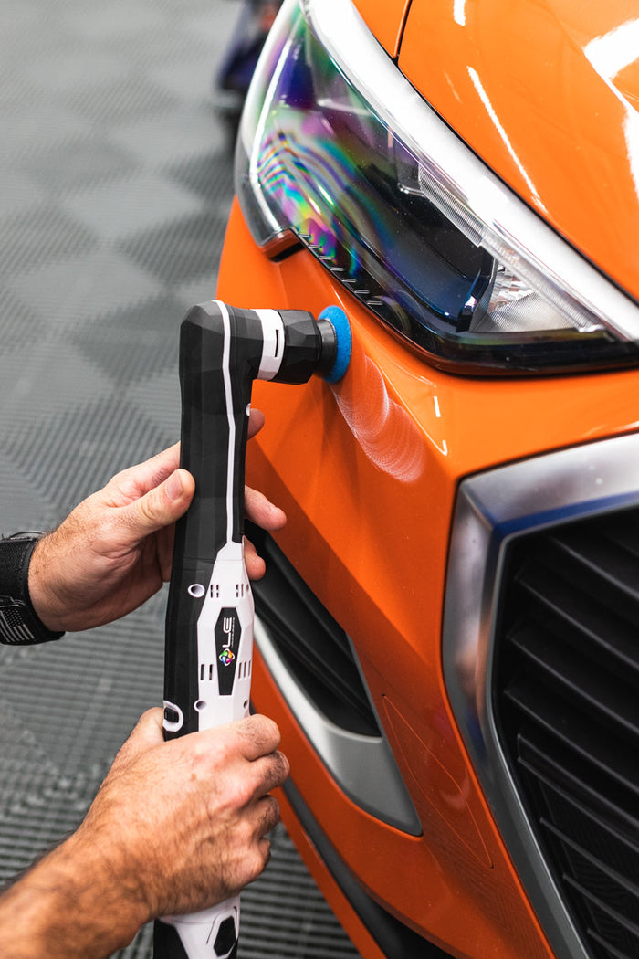 A person using a rupes da coarse pad on a polisher.