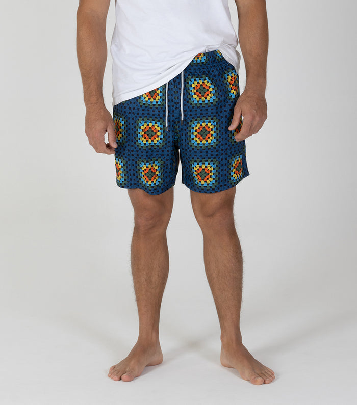 crochet Person wearing blue patterned shorts on a white background