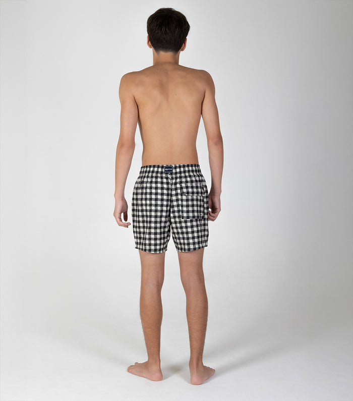 gingham Person wearing black and white checkered shorts on a plain background