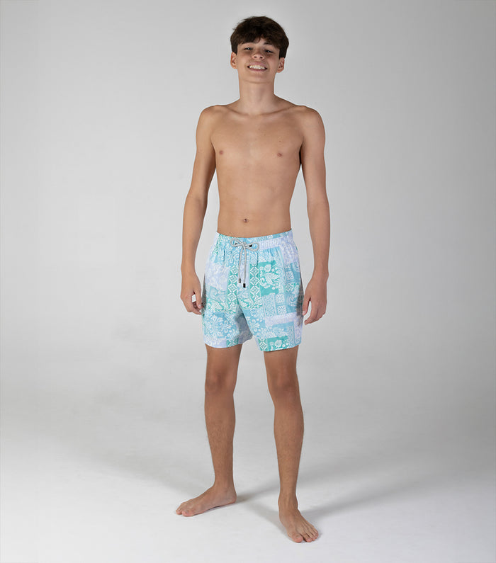paisley Young man wearing light blue swim shorts with a pattern on a white background