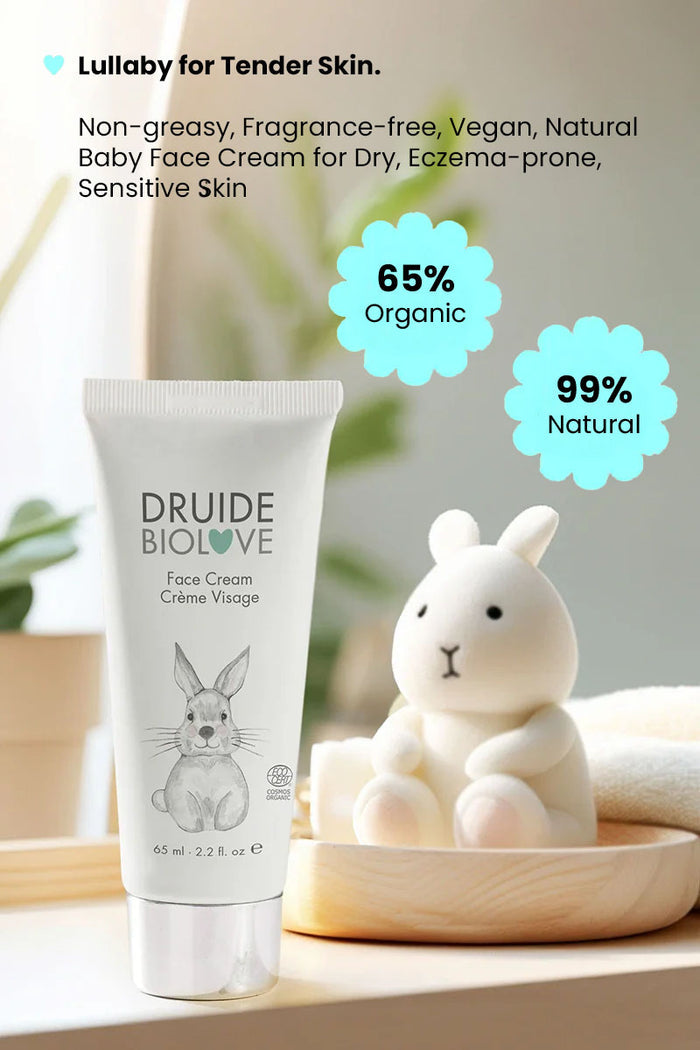 Druide Biolove organic baby face cream 
 sitting on a shelf with green plants and a teddy bear toy in background with text reading "99% natural, 65% organic, lullayby for tender skin. non greasy, fragrance free, vegan, natural baby face cream for dry eczema prone sensitive skin".