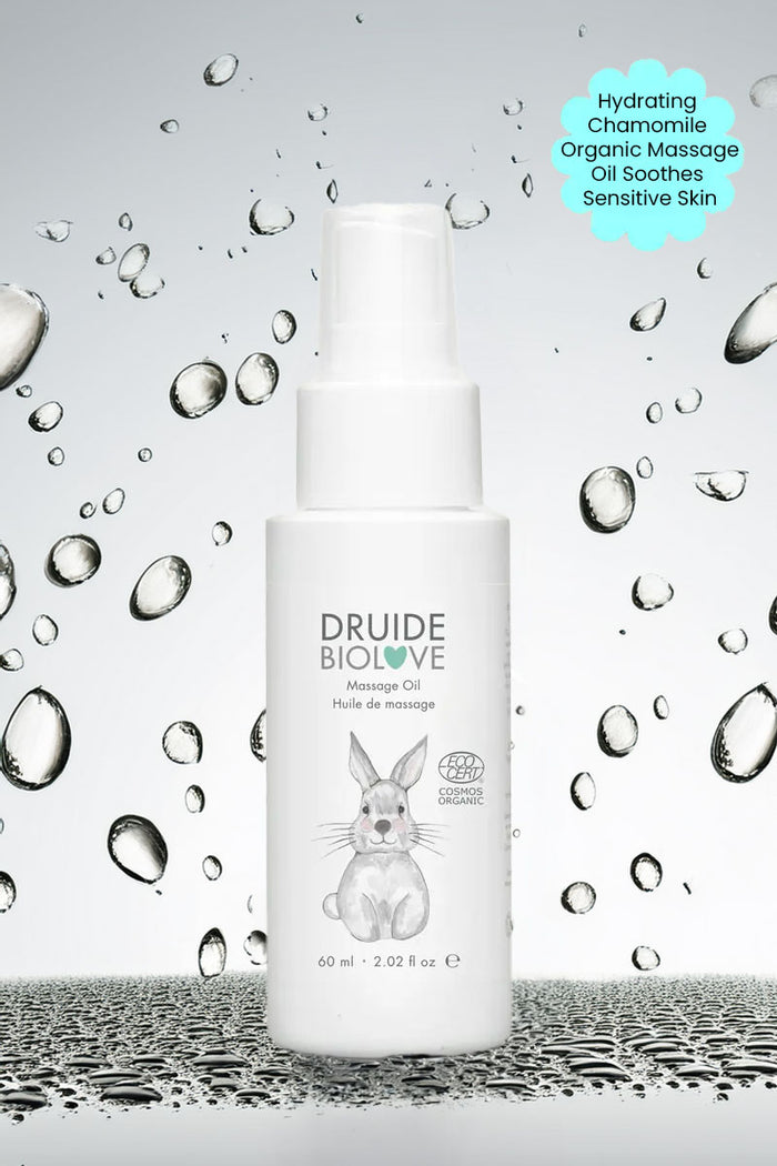 Druide Biolove organic massage oil against background if water beads with text "hydrating chamomile organic massage oil soothes sensitive skin".