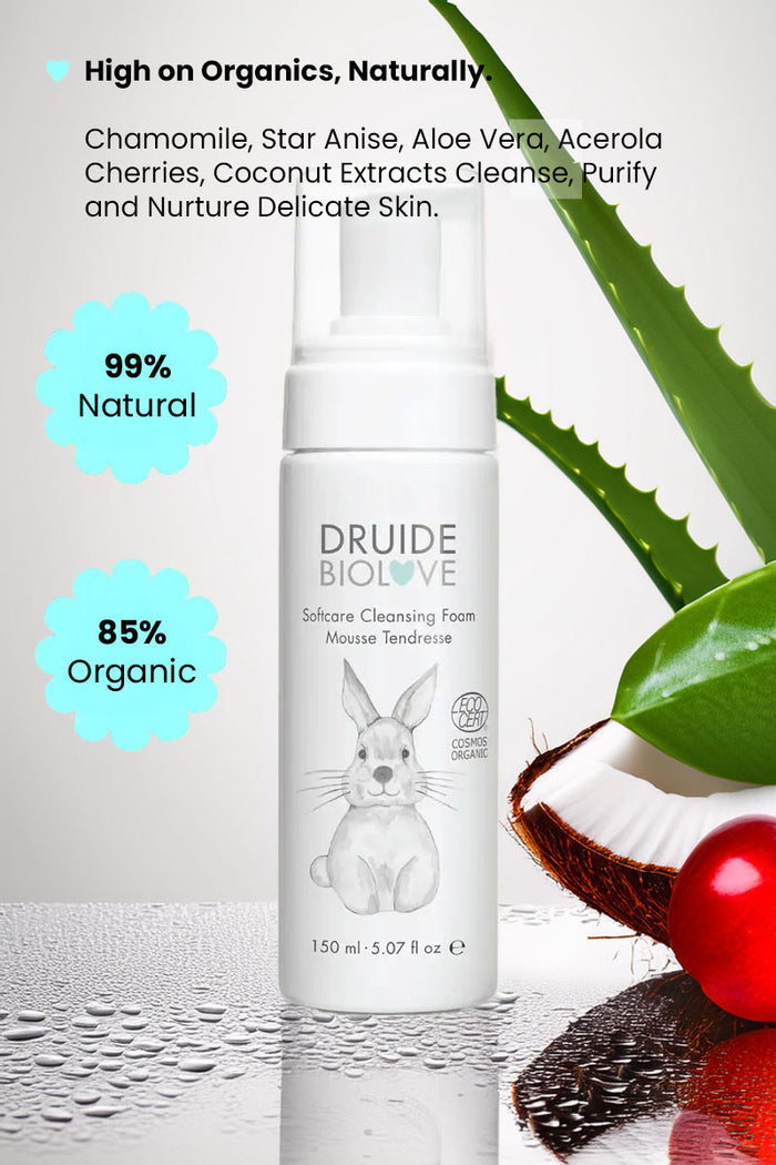 Druide Biolove Organic Baby Wash Cleansing Mousse dispenser placed next fresh aloe vera stem, acerola cherry and a cracked coconut with text reading "99% natural, 85% organic", high on organics naturally, chamomile, star anise, aloe vera, acerola cherries, coconut extracts cleanse, purify, and nurture delicate skin".