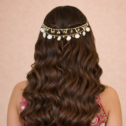 Woman with wavy hair wearing a decorative headband on a beige background