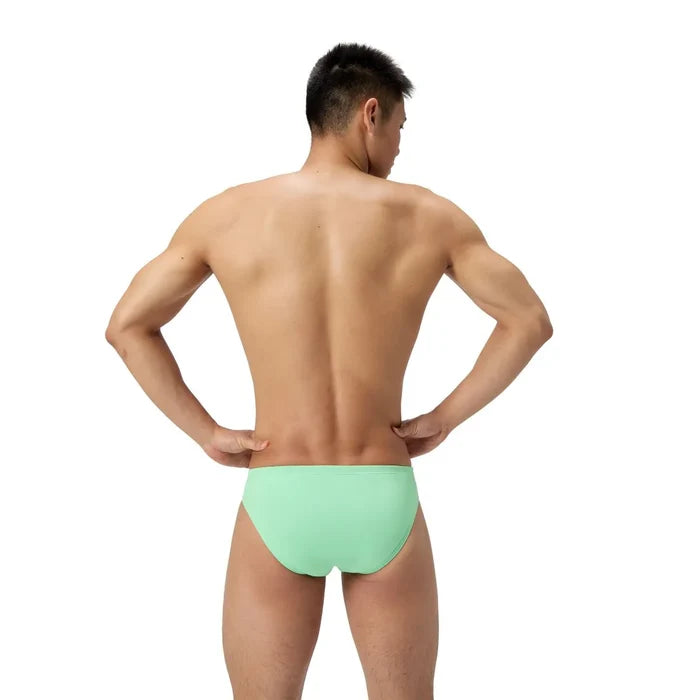 Speedo men's ML solid brief in alfalfa green, close-up view showing the snug fit and elastic waistband of the swimwear.