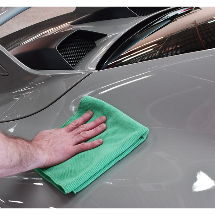 Using a Pearl towel from The Rag Company in a green color, measuring 16 inches by 16 inches, to detail the exterior of a grey sports car.