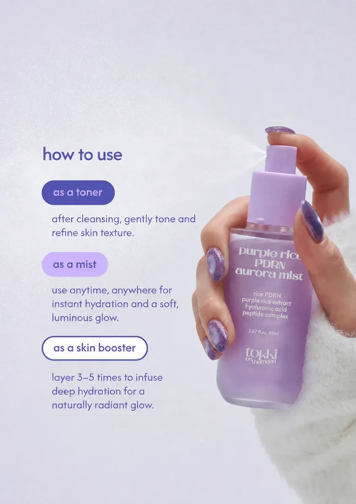A hand with purple glitter nail polish holds a bottle of TDKJ Aurora Mist toner. The image features a light lavender background with text detailing how to use the mist as a toner, mist, or skin booster.