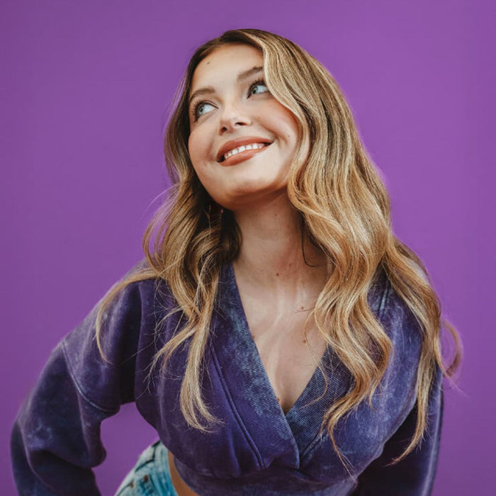 Woman wearing a purple top against a purple background