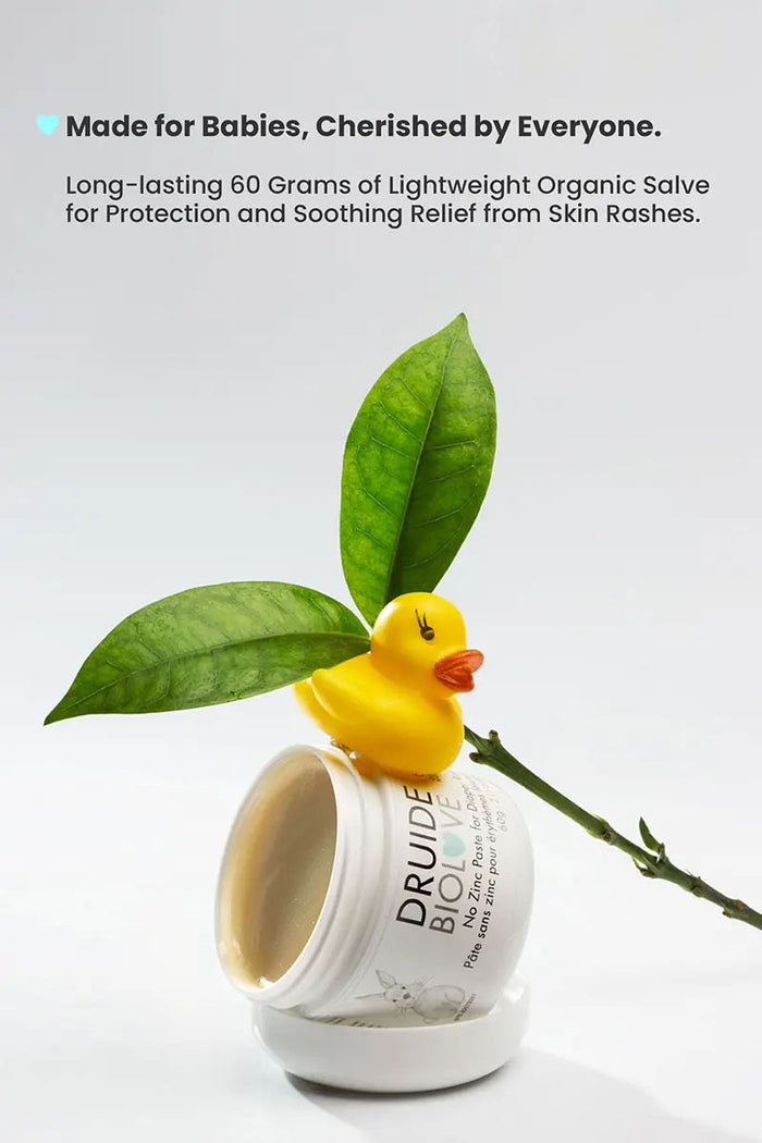Druide Biolove organic baby balm  tub opened showing natural pale olive colour and balm texture with a yellow rubber duck toy atop and a green leaf in background with text reading "made for babies, cherished by everyone, long lasting 60 grams of lightweight organic salve for protection and soothing relief from skin rashes".